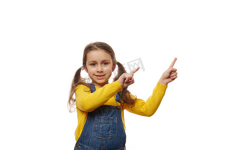 一个留着两个马尾辫的迷人小女孩的情感肖像，手指指向复制广告空间以获取促销文字。