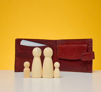 皮革棕色钱包背景中一家人的木制小雕像