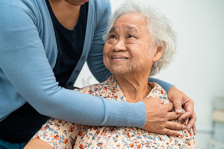 护理人员在护理医院用爱、关怀、鼓励和同情帮助亚洲老年女性患者，健康强大的医疗理念。