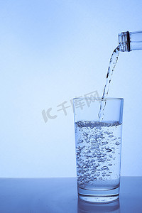 新鲜干净的水从瓶子里倒进玻璃杯里。