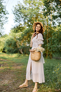 一位身穿浅色夏装、头戴柳条帽的女士站在森林里，手里拿着一篮雏菊