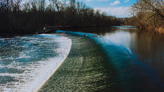 快速流动的水在冬季前冲过人造水坝