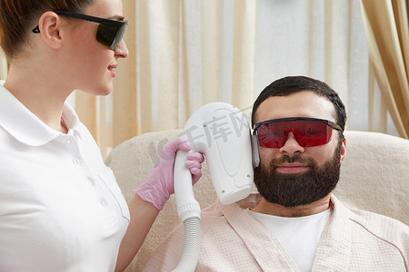 大胡子男子在美容诊所接受专业美容师的激光面部治疗