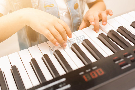 孩子的手在钢琴键盘上