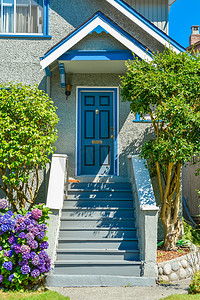 住宅外部摄影照片_门廊下家庭住宅的蓝色入口门，前面有门阶