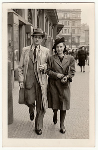 复古照片显示一对年轻夫妇走在街上。