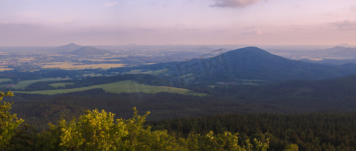 Lusatian 山脉 (luzicke hory) 宽全景，从捷克与德国边境的 Hochwald (Hvozd) 山全景，蓝绿色的山林和粉红色的多云日落天空背景