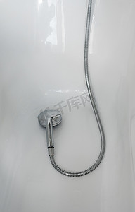 清爽浴室摄影照片_浴室浴缸中带软管的淋浴喷头。
