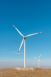 风力发电机摄影照片_多台风力涡轮机在日出时站在山上发电
