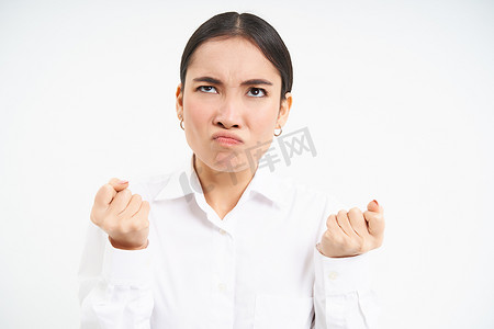 愤怒、愤怒的女商人的画像，日本女士握紧拳头，站在白色背景上，脸上带着烦恼、沮丧的表情抬头
