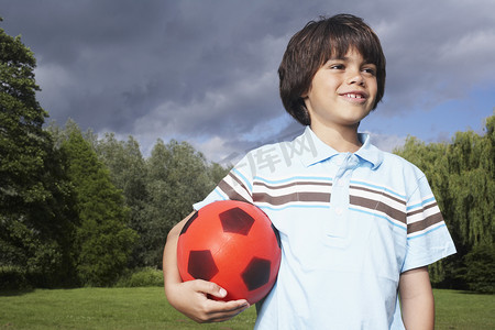 足球足球草田摄影照片_草地上男孩的肖像，足球看着别处