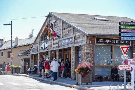 angles摄影照片_夏季，人们在 Les Angles 滑雪胜地的 Tourism Ofiice 等候
