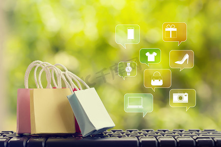 在线营销/支付概念：电脑键盘上带有智能手机的购物袋、图标在线购物和社交媒体网络。