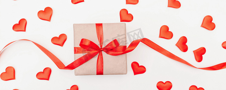 hearts摄影照片_带有红色蝴蝶结的 Baner Hearts 礼品盒，白色背景上带有红心。
