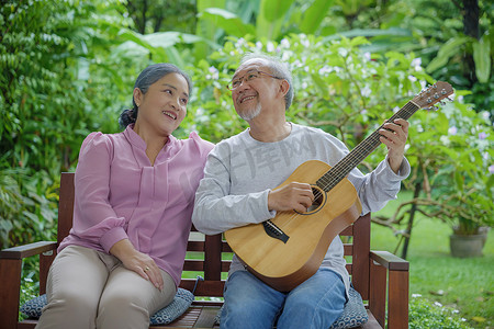 唱歌聚会摄影照片_老夫妇弹吉他，而他的妻子正在一起唱歌
