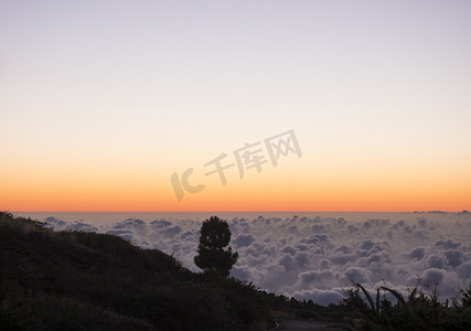石子摄影照片_西班牙加那利岛拉帕尔马山脉白云覆盖的日落后美丽的红光