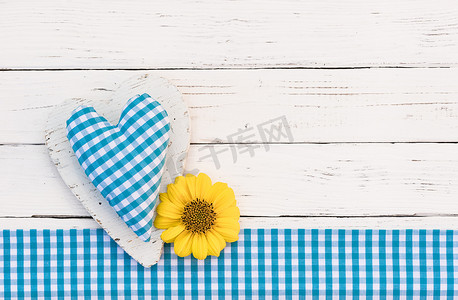 心脏蓝色背景摄影照片_与蓝色心脏和黄色花的贺卡