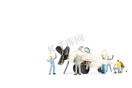 工人团队在白色背景下修理玩具飞机
