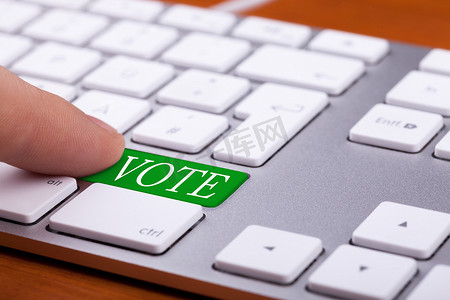 手指按下键盘上的投票绿色按钮