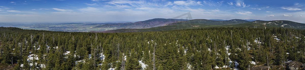 Jizera Mountains jizerske hory 全景景观，从 holubnik 山的山顶可以看到郁郁葱葱的绿色云杉林、树木、巨石和蓝天背景，春天还有雪