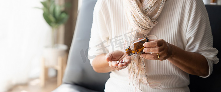中老人摄影照片_特写成熟女性从瓶子、补充剂或抗生素中取出药丸，年长女性准备服用急救药物、慢性病、保健和治疗概念