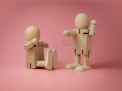 2 个木娃娃坐着和站着说话手势在粉红色的 ba 上