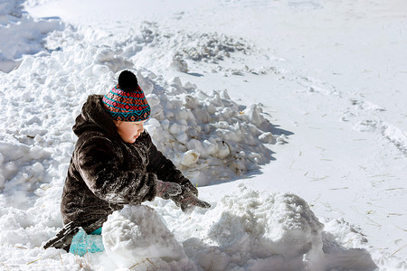 美丽快乐的小孩在乡间院子里玩雪