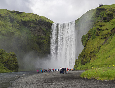 冰岛南部 Skogar 美丽的 Skogafoss 瀑布与一群穿着五颜六色的游客