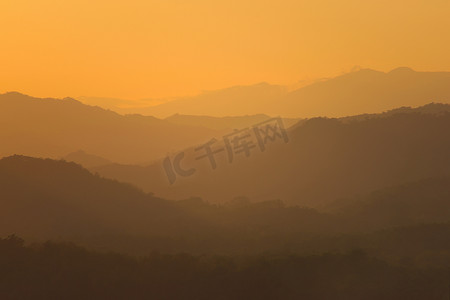 老挝琅勃拉邦周围朦胧山脉上空的橙色天空。
