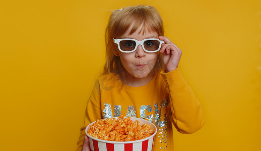 兴奋的小女孩吃爆米花，看电视连续剧，体育游戏，电影，在线社交媒体电影