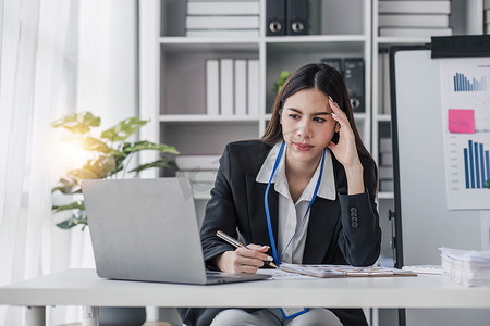 亚洲女性苦思冥想关注在线问题解决方案看着笔记本电脑屏幕，担心严肃的亚洲女商人专注于解决困难的工作计算机任务。