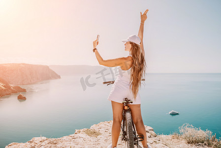 眺望山摄影照片_一位骑山地自行车的女自行车手，眺望山海风光。