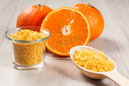 用两个完整的橙子、玻璃碗和海盐木勺切橙子
