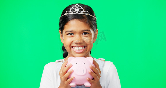 孩子金钱摄影照片_在工作室里，绿色屏幕旁的女孩、存钱罐和面带微笑的脸，以节省模型、金钱或公主的审美。