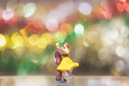 微型人物：散景背景下的情侣浪漫舞蹈
