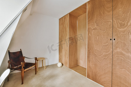 一间带椅子和木制衣橱的小房间