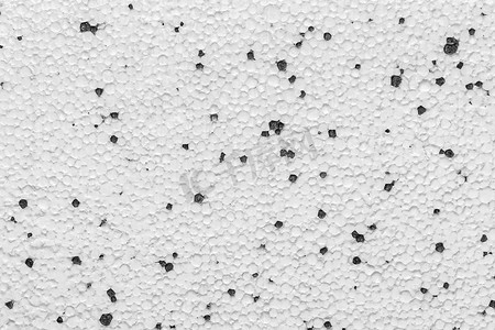 泡沫塑料聚苯乙烯石膏板干墙泡沫建筑材料表面白色与抽象黑色图案点墙纹理背景
