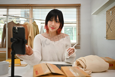 年轻的亚洲女性小企业主穿着休闲服，在网上商店查看客户地址或订单
