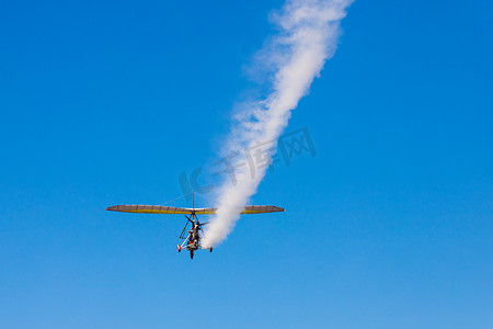 参数化摄影照片_带轮子摇篮的滑翔伞在蓝天上留下一条白色的痕迹