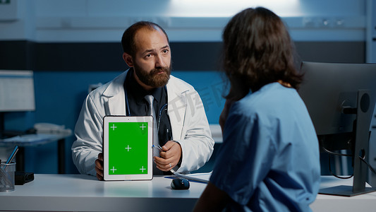 模板医院摄影照片_医生拿着数字设备指向绿屏色度键模板