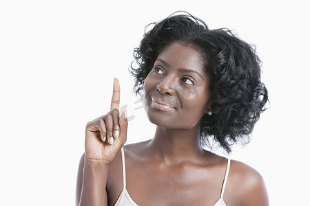 非裔美国年轻女性在白色背景中将食指向上指