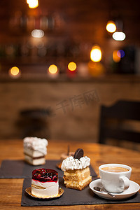咖啡店点心摄影照片_咖啡店木桌上的各种甜点蛋糕