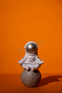 五颜六色的橙色背景的塑料玩具宇航员复制空间。