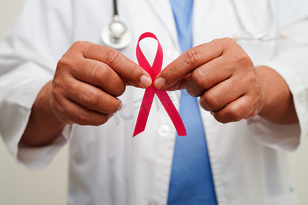 乳腺癌治疗摄影照片_10 月世界乳腺癌日，带粉红丝带的亚洲女医生。