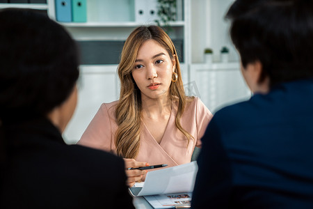 年轻的亚洲女性候选人试图通过称职给面试官留下深刻印象。