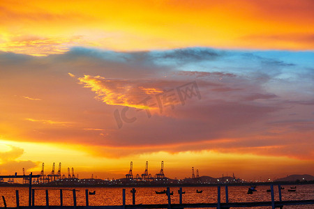 海港上的起重机和夕阳红蓝天和 s 上的渔船