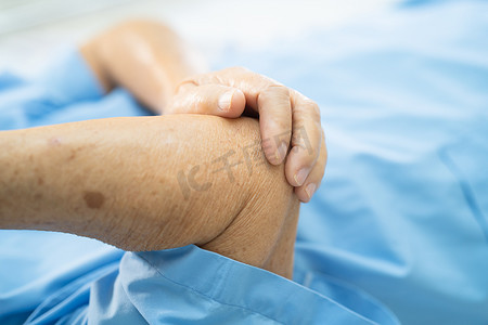 亚洲老年或老年老妇人患者在护理医院病房的床上感到肘部疼痛，健康强大的医疗理念。