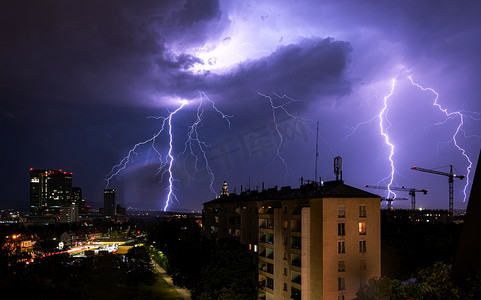 雷电png摄影照片_维也纳维纳贝格市上空出现猛烈的夏季雷暴和巨大的闪电，图片右侧有建筑起重机