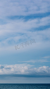 优雅释放摄影照片_横幅，垂直故事大气全景白云清澈的蓝天地平线平静空旷的大海。