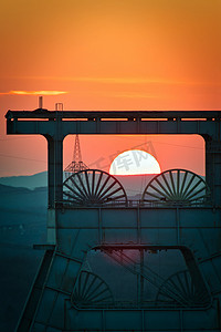 德国赫尔滕背景金色太阳落山的头架塔的垂直拍摄